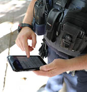 A picture of a police officer in uniform using a mobile phone 