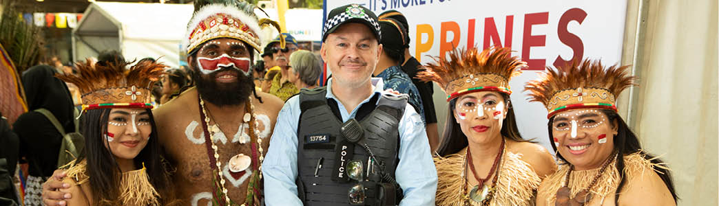 A uniformed police officer with members of the multicultural community 