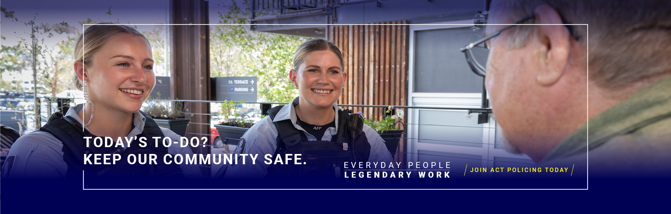  2 female police officers in uniform sitting at a cafe with a member of the community having a friendly chat